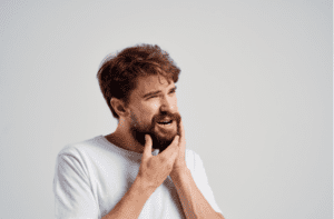man touches his beard with his hand jaw toothache