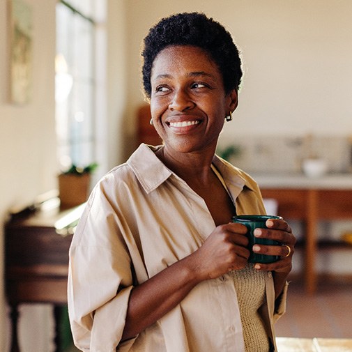 Smiling woman enjoying coffee at home