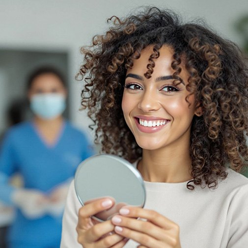 Woman smiling while holding small mirror