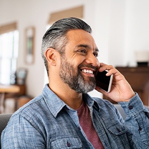 Man smiling while talking on phone