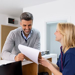 Dental team member assisting patient at front desk