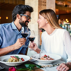Couple smiling while enjoying glass of wine in restaurant