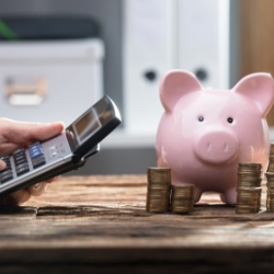 Pocket calculator used near piggy bank